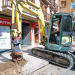 Excavadora retirando un tocón, tras haber excavado el perímetro