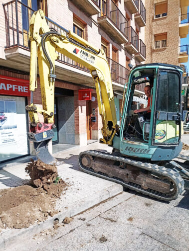 Excavadora retirando un tocón, tras haber excavado el perímetro