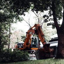 Excavadora procediendo al desbroce de un terreno agreste.