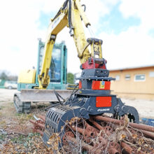 Excavadora con accesorio pinza para manipulación de elementos como tubos, rocas, etc.